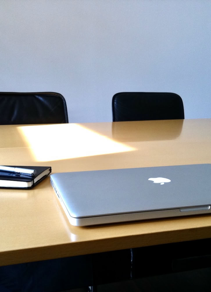 Business colleagues discussing at a meeting with a digital tablet. Indoor setting with focus on collaboration.