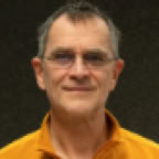 Confident male consultant takes notes, surrounded by legal paperwork in a modern office.